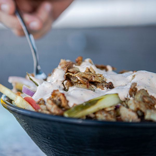 Loaded Shawarma Fries - A bowl of loaded shawarma fries topped with juicy shawarma meat, tomatoes, pickles, onions, and drizzled with garlic sauce, ready to be enjoyed in Port St Lucie Tradition and Fort Pierce at Swift Grill.