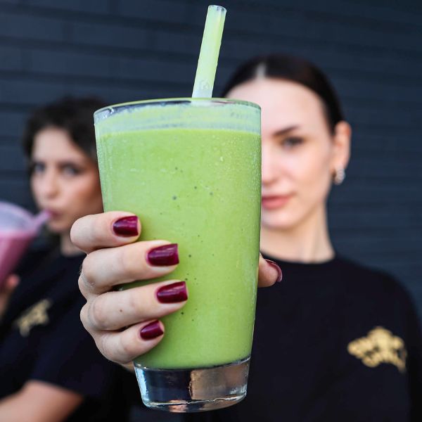 Refreshing Smoothies at Swift Grill in Tradition and Fort Pierce Florida - A refreshing green smoothie held up close with a vibrant background, highlighting the freshness and appeal of the drink.