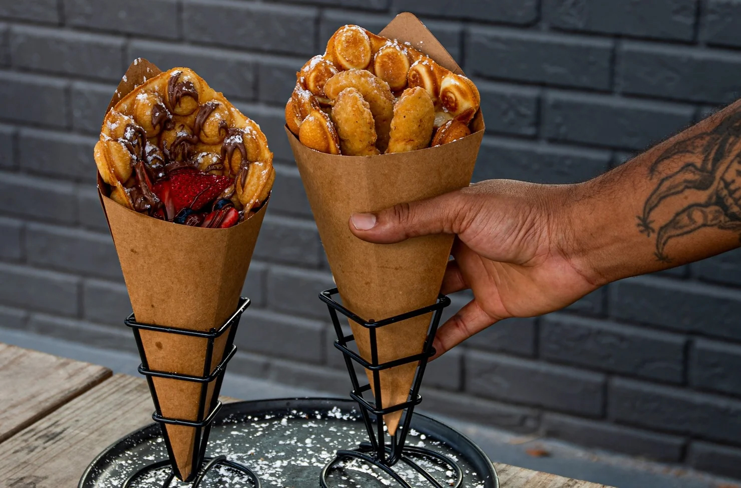 a hand holding a couple of waffle cones