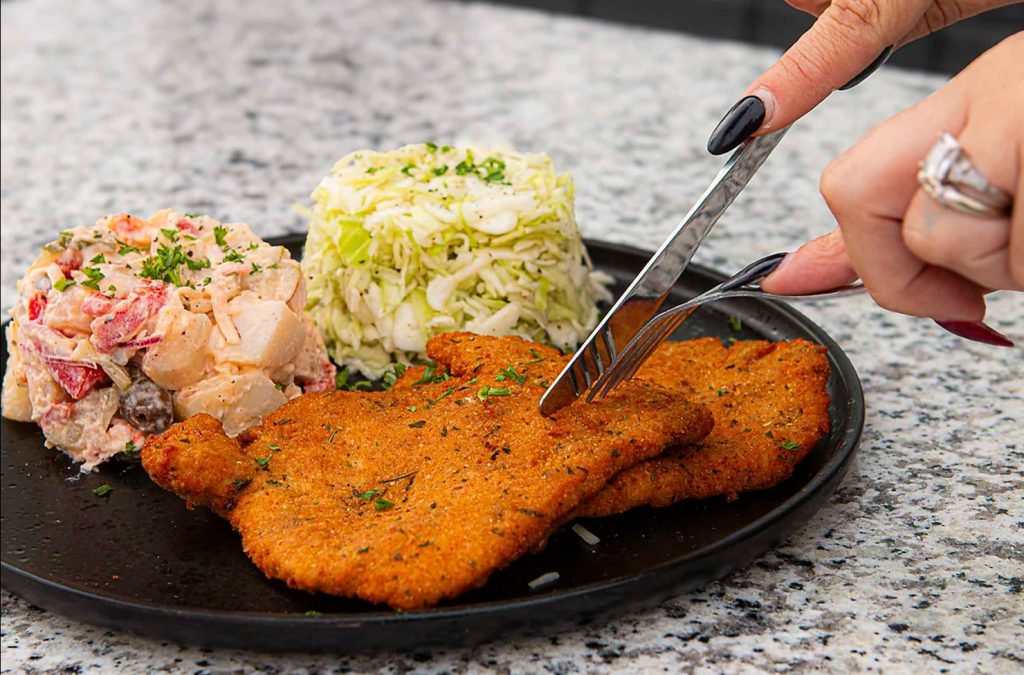 a person cutting food on a plate