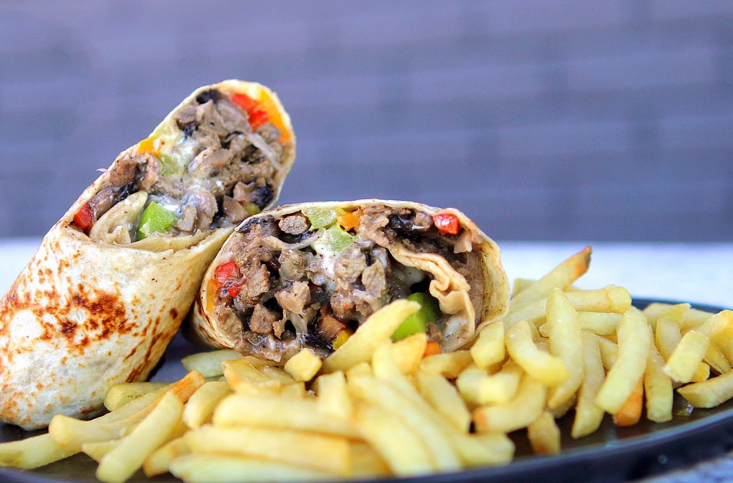 a burrito and french fries on a plate